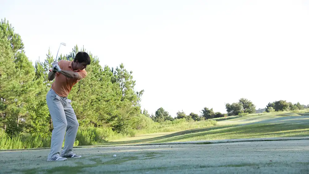 Student preparing to swing on a golf course.