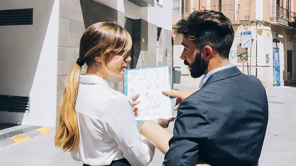 A man and woman discussed building plans on a clipboard.