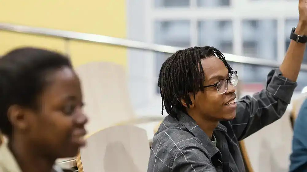 A student raising their hand in class.