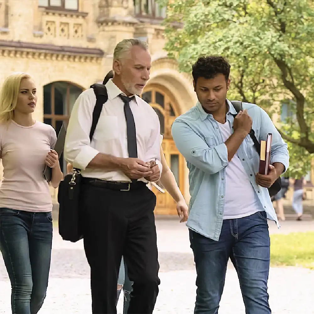 Two women looking at each other, smiling, sitting down, working on an assignment.