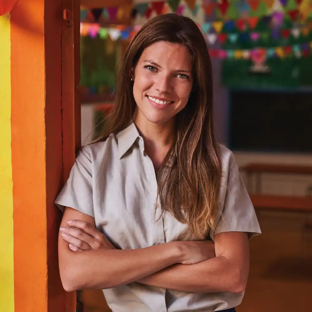Two women looking at each other, smiling, sitting down, working on an assignment.