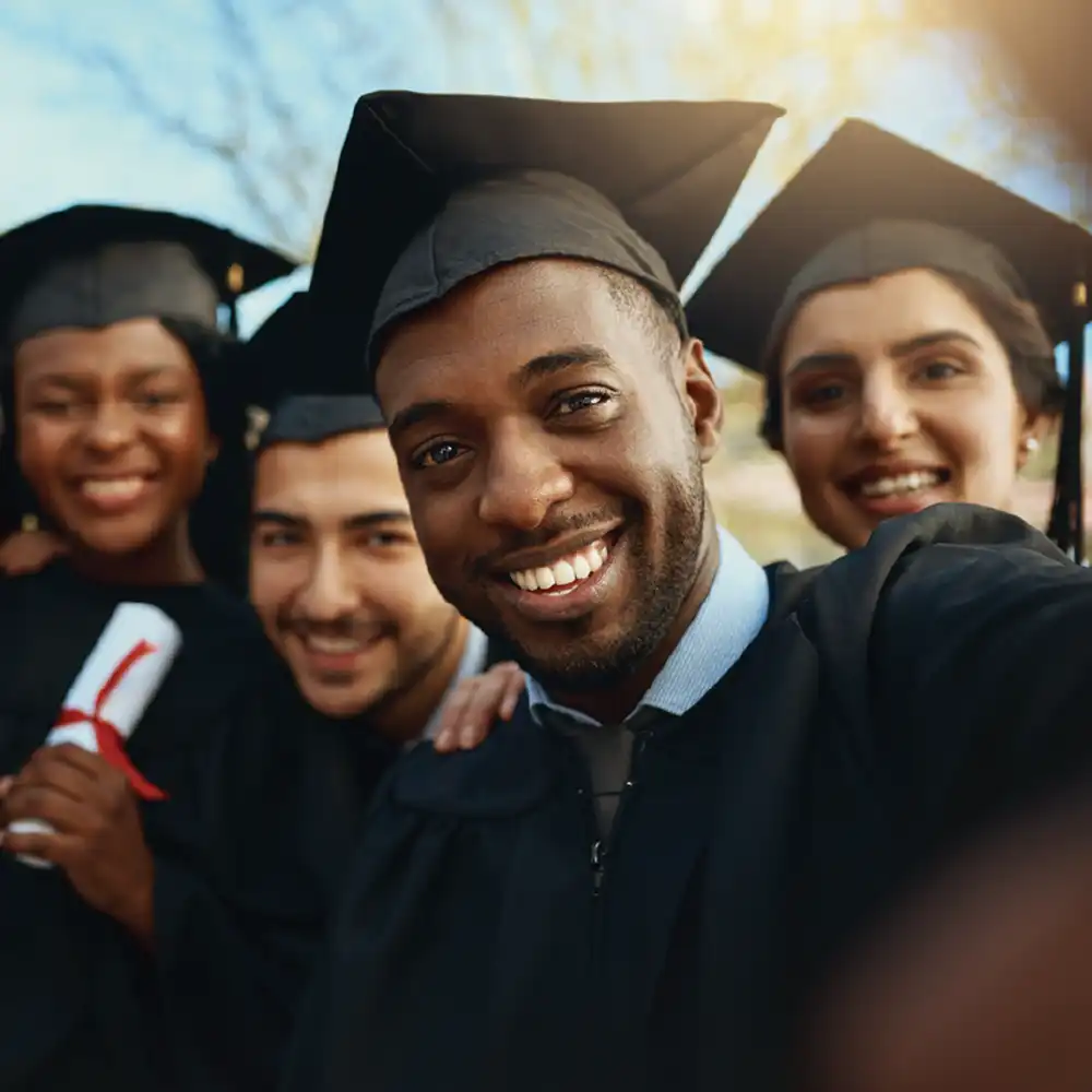 Two women looking at each other, smiling, sitting down, working on an assignment.