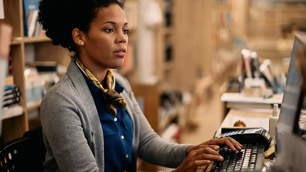 Woman in professional clothes focusing on typing on her computer
