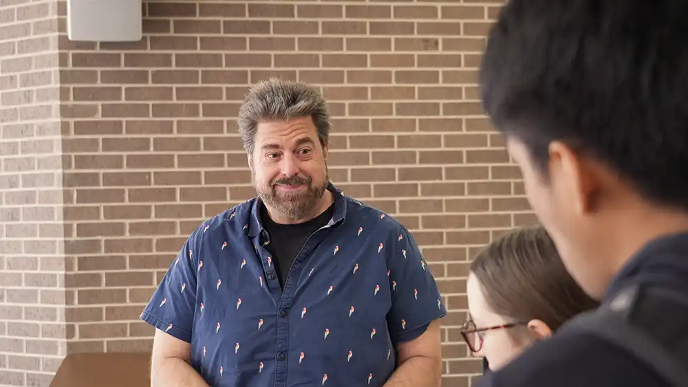 Professor smiling talking to students