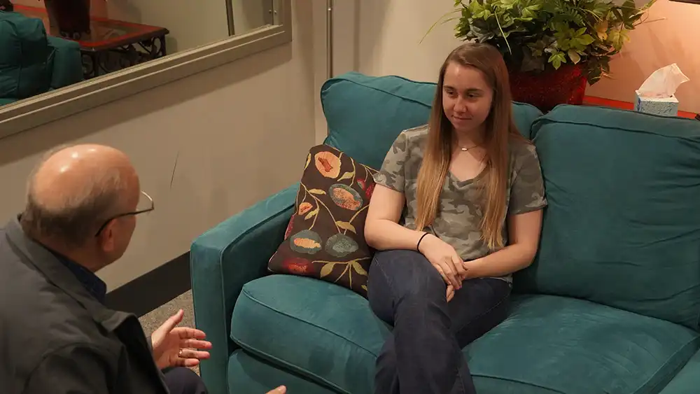Man sitting on a couch across from a woman sitting on a couch