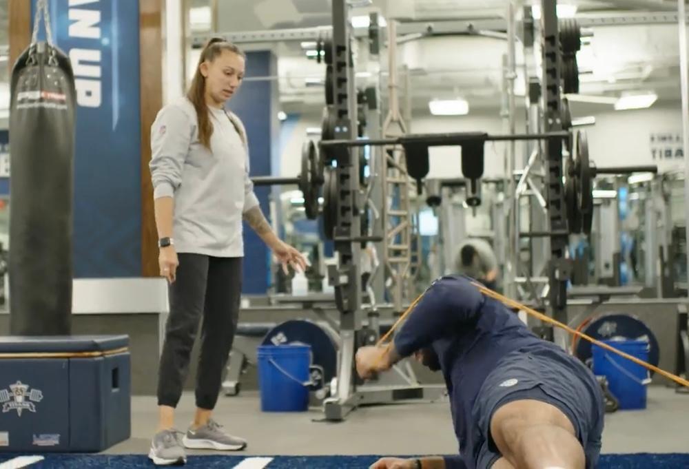 Two women looking at each other, smiling, sitting down, working on an assignment.