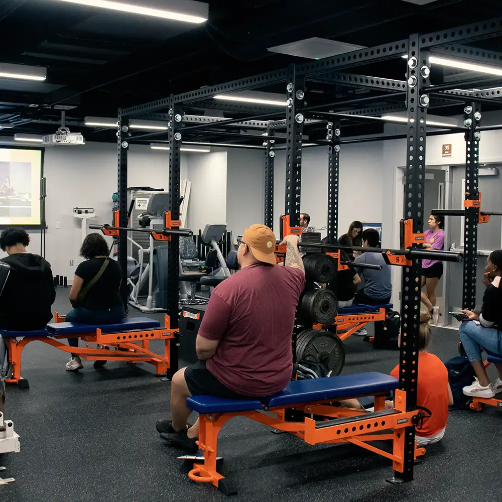 Two women looking at each other, smiling, sitting down, working on an assignment.
