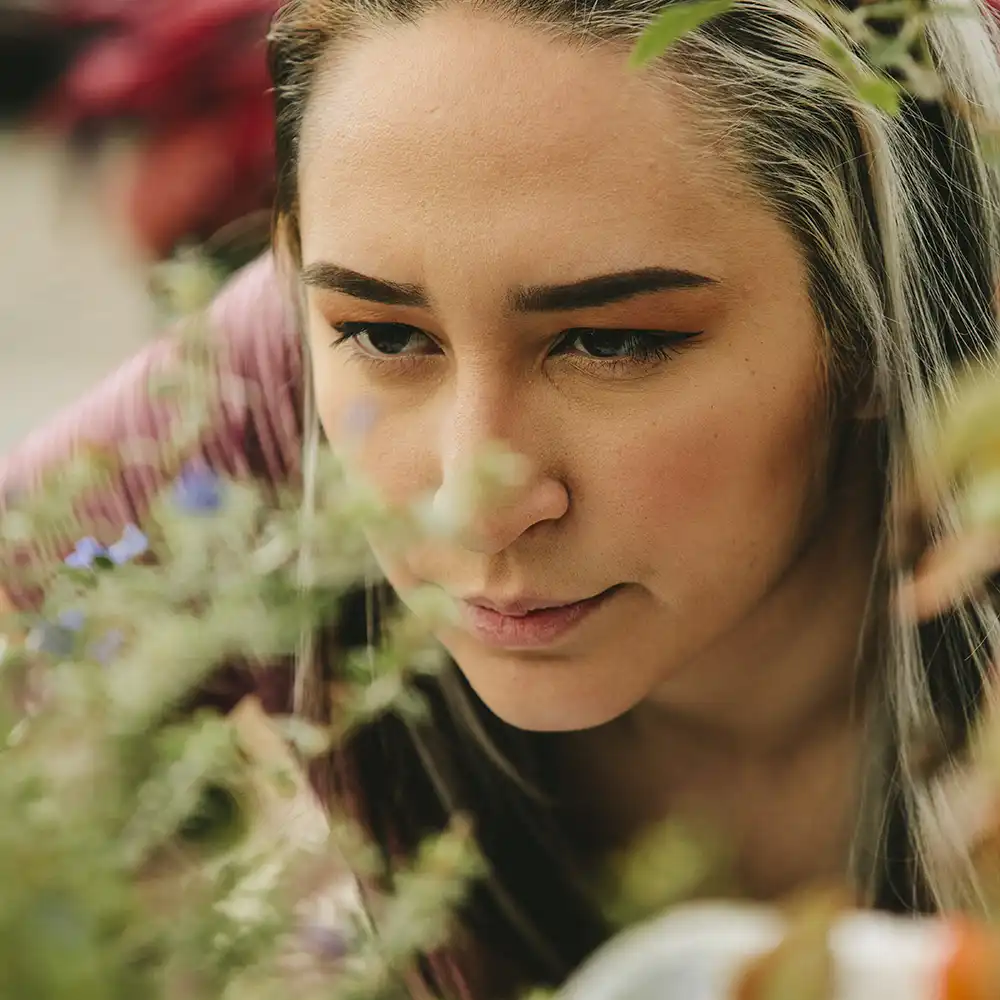 SHSU Student looking at a plant in the Gibbs Ranch Green House