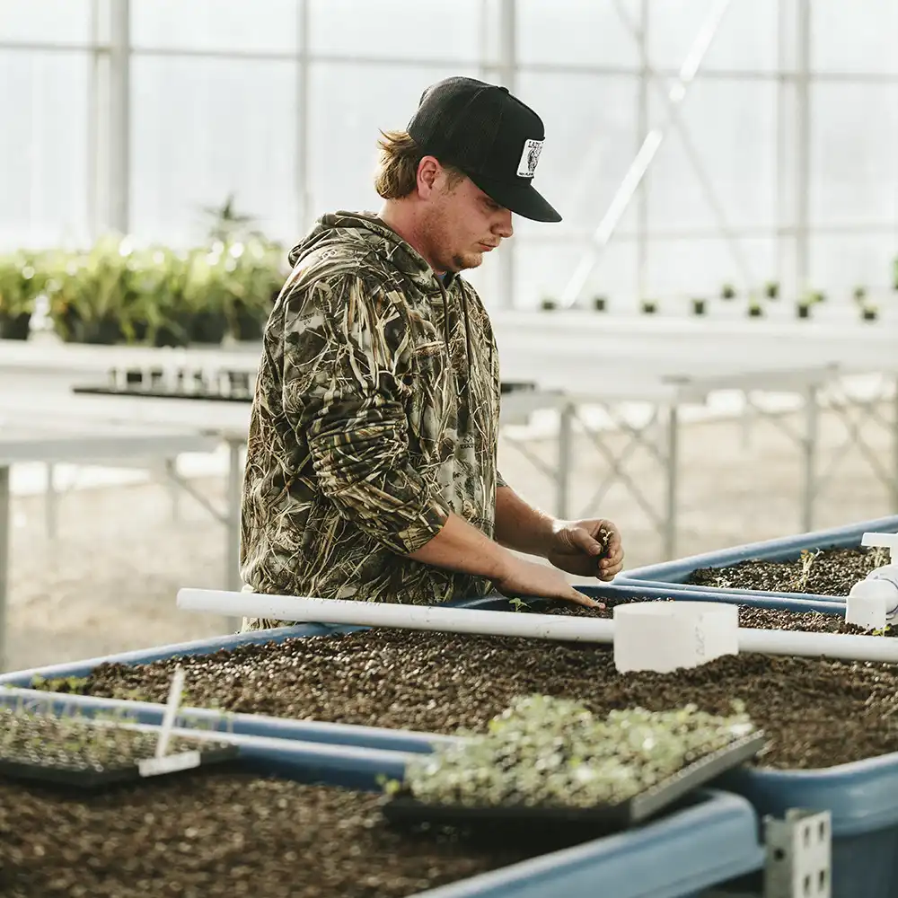 Male student working in the Green House at Gibbs Ranch
