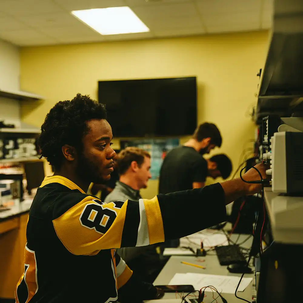 Two women looking at each other, smiling, sitting down, working on an assignment.