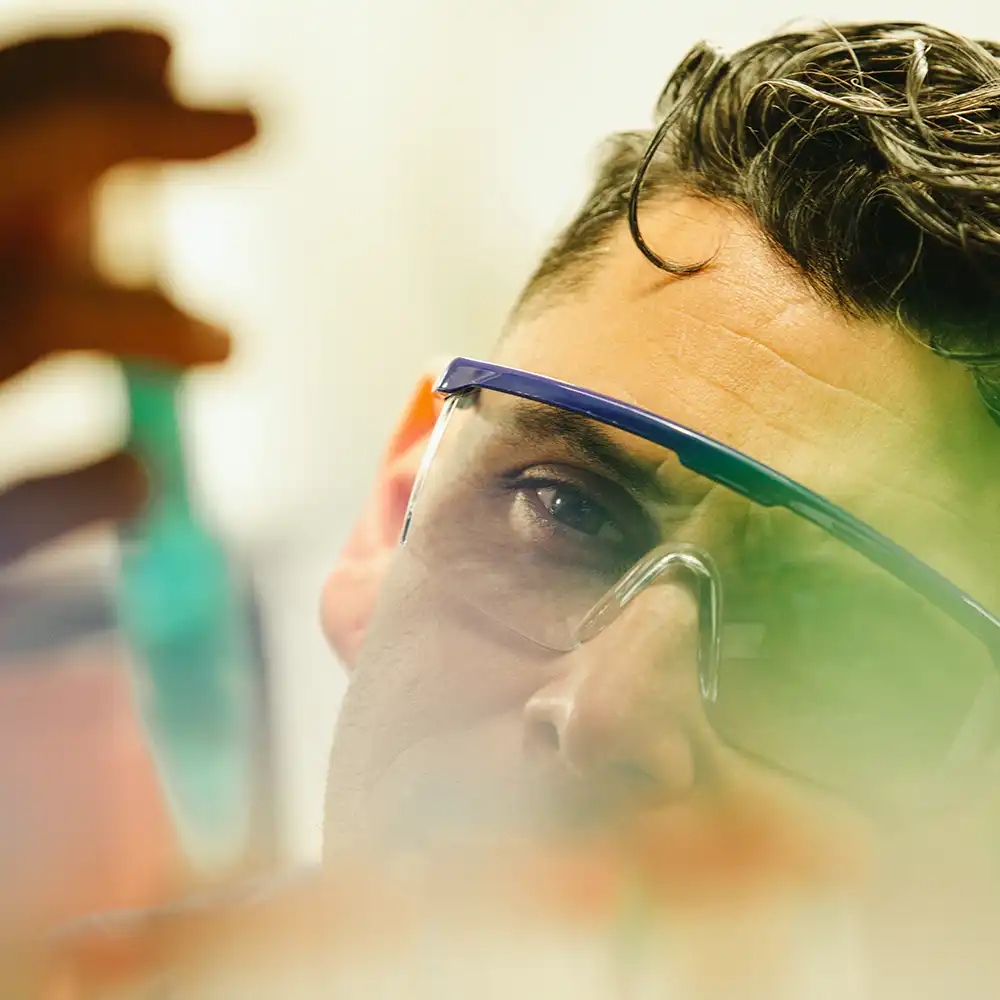 Two women looking at each other, smiling, sitting down, working on an assignment.