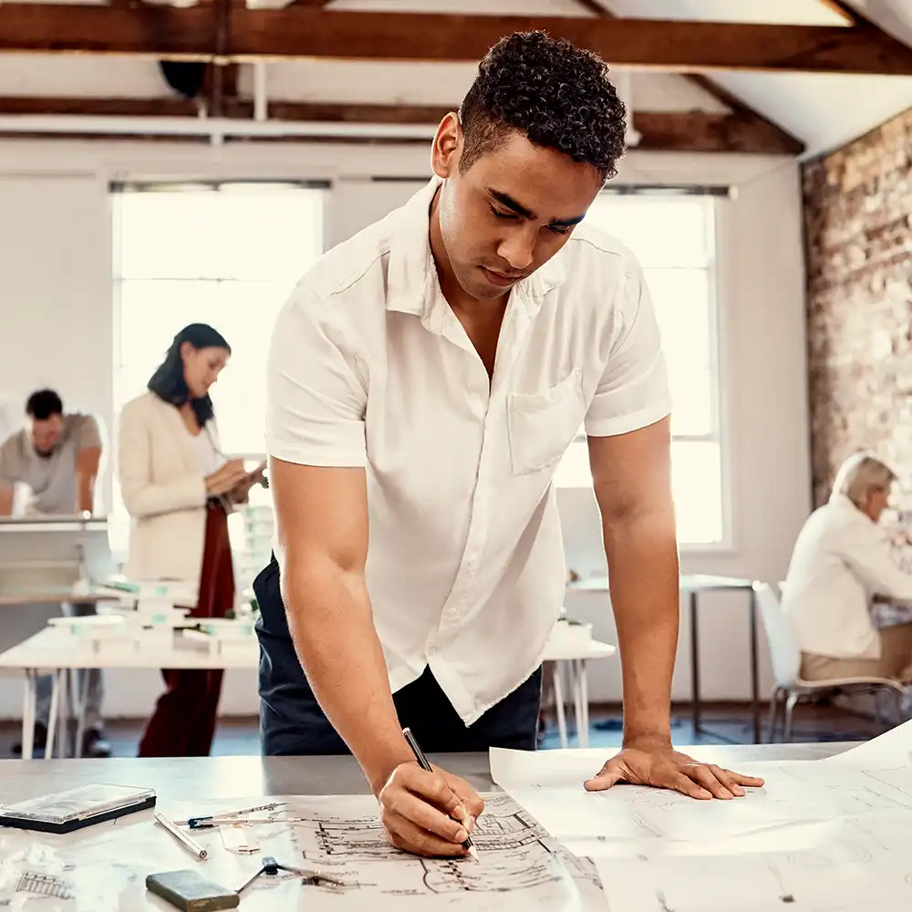 Two women looking at each other, smiling, sitting down, working on an assignment.