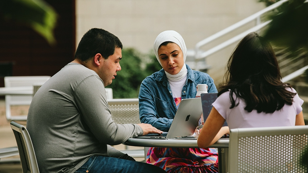 SHSU Students working together at a table on laptops