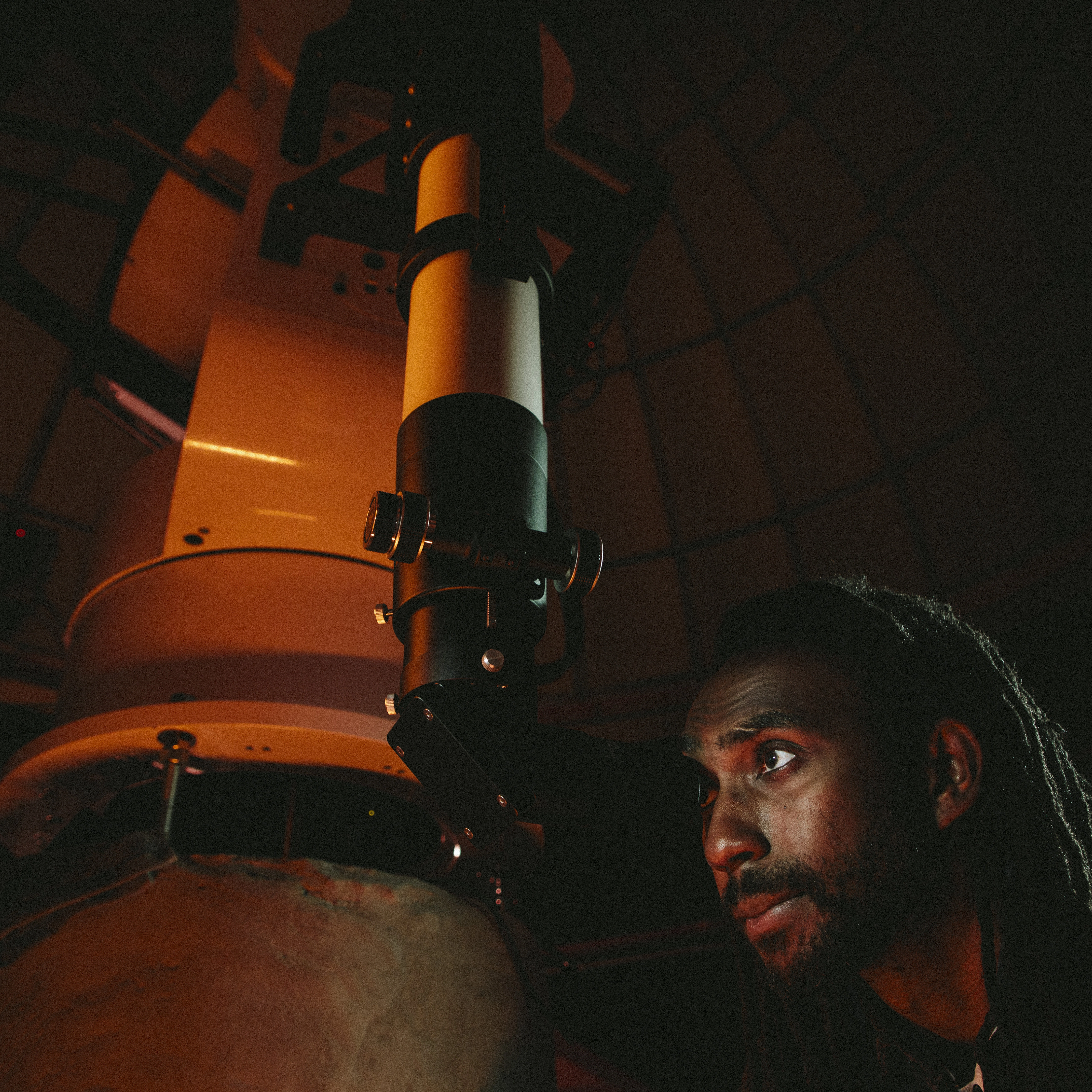 A student looking through a telescope.