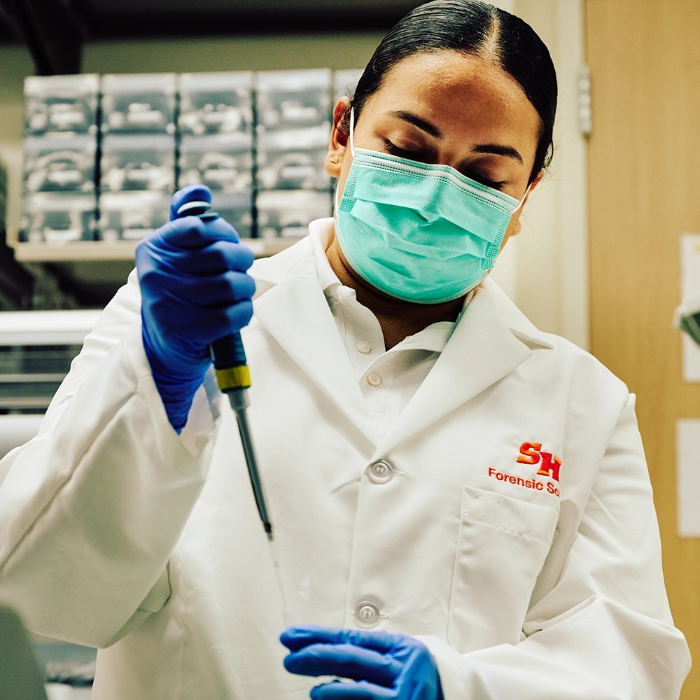 Two women looking at each other, smiling, sitting down, working on an assignment.