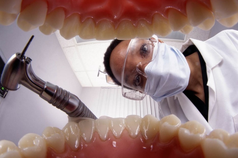 Dentist looking at the teeth of a patient from inside patients mouth