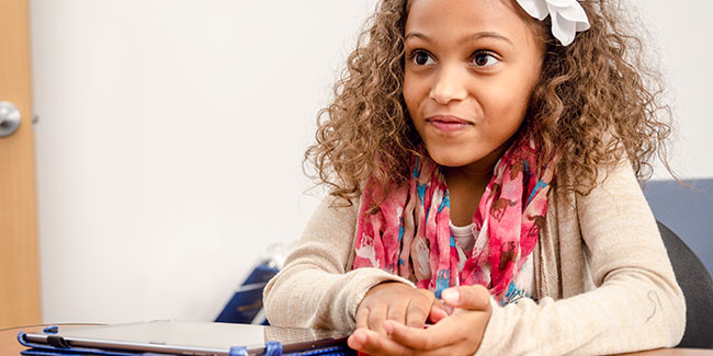 A little girl listens attentively to the speaker.