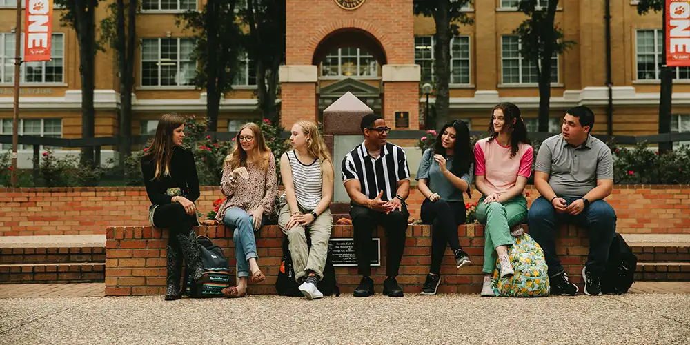 Students sitting in a group in front of clock tower