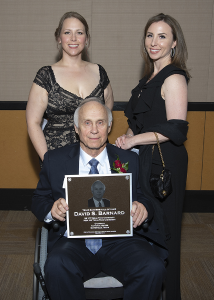 Barnard poses with two others with plaque