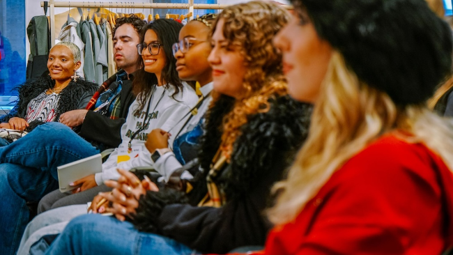 Carlena Blanco (third from left) listens to a presentation during UofNYFW.