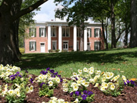 Austin Hall Close Up of Flower Bed and Large Trees Providing Shade