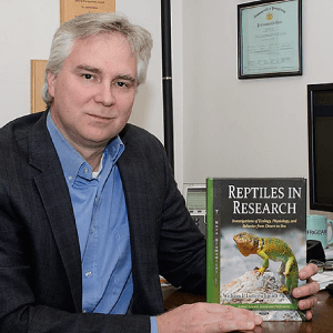 A Professor holding a book, photograph for the section Reptiles need love too.