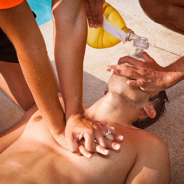 Two people giving demonstrating CPR on a person