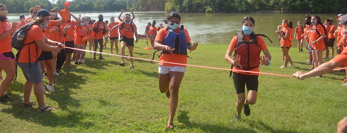 campers running relay race with facemasks