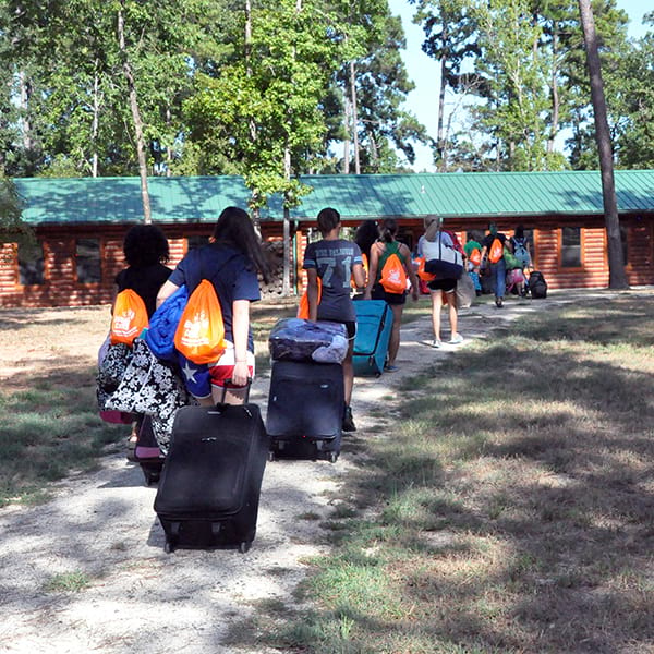 campers walking up to camp with luggage