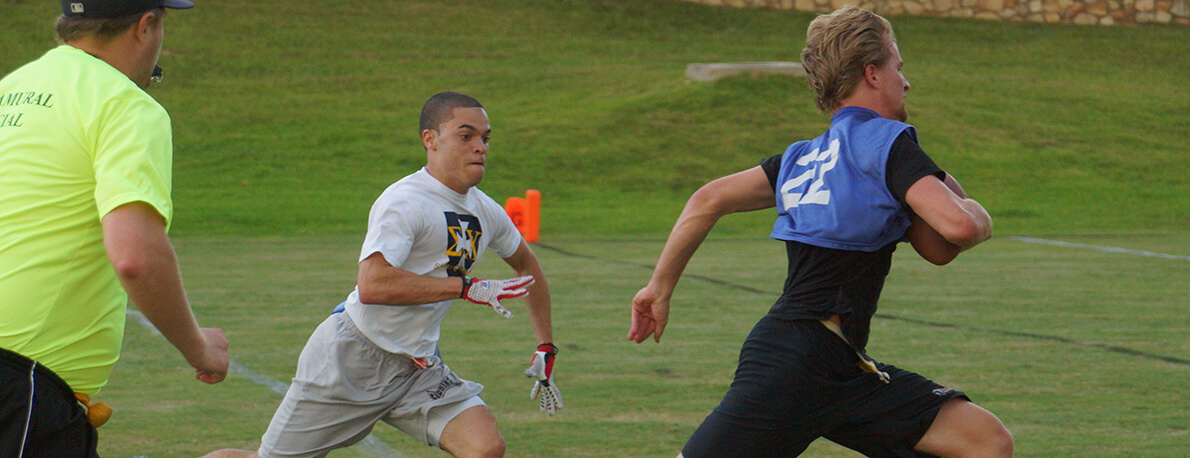 flag football players chasing one another to pull flag