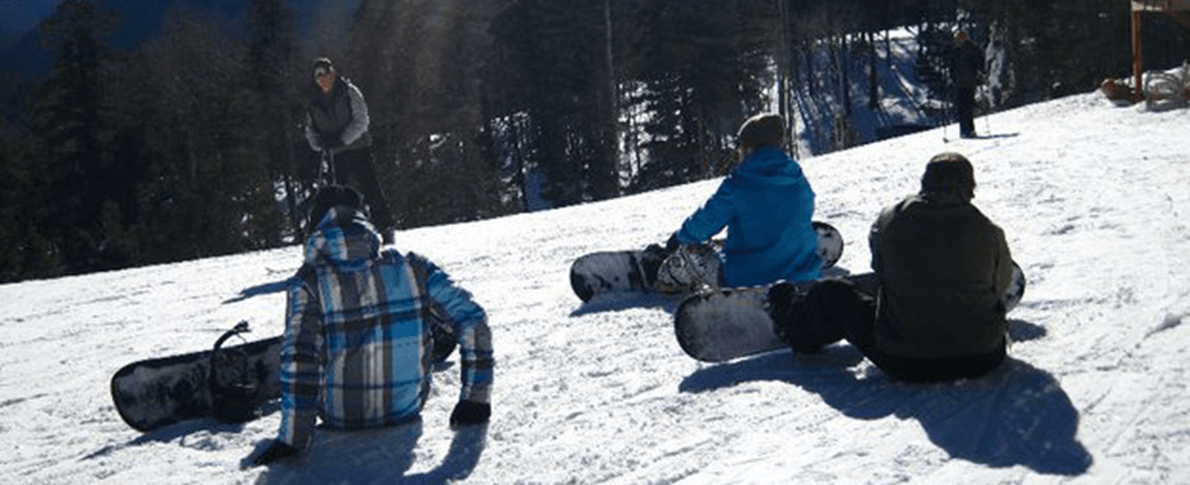 three Skiers sitting on hill