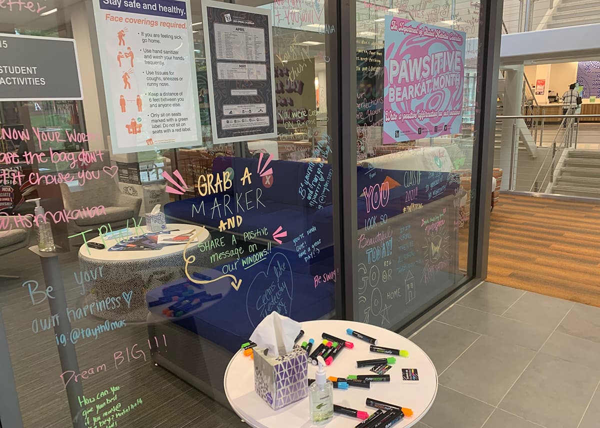 The glass walls of the Student Affairs office have been written on by students, faculty, and staff with positive messages.