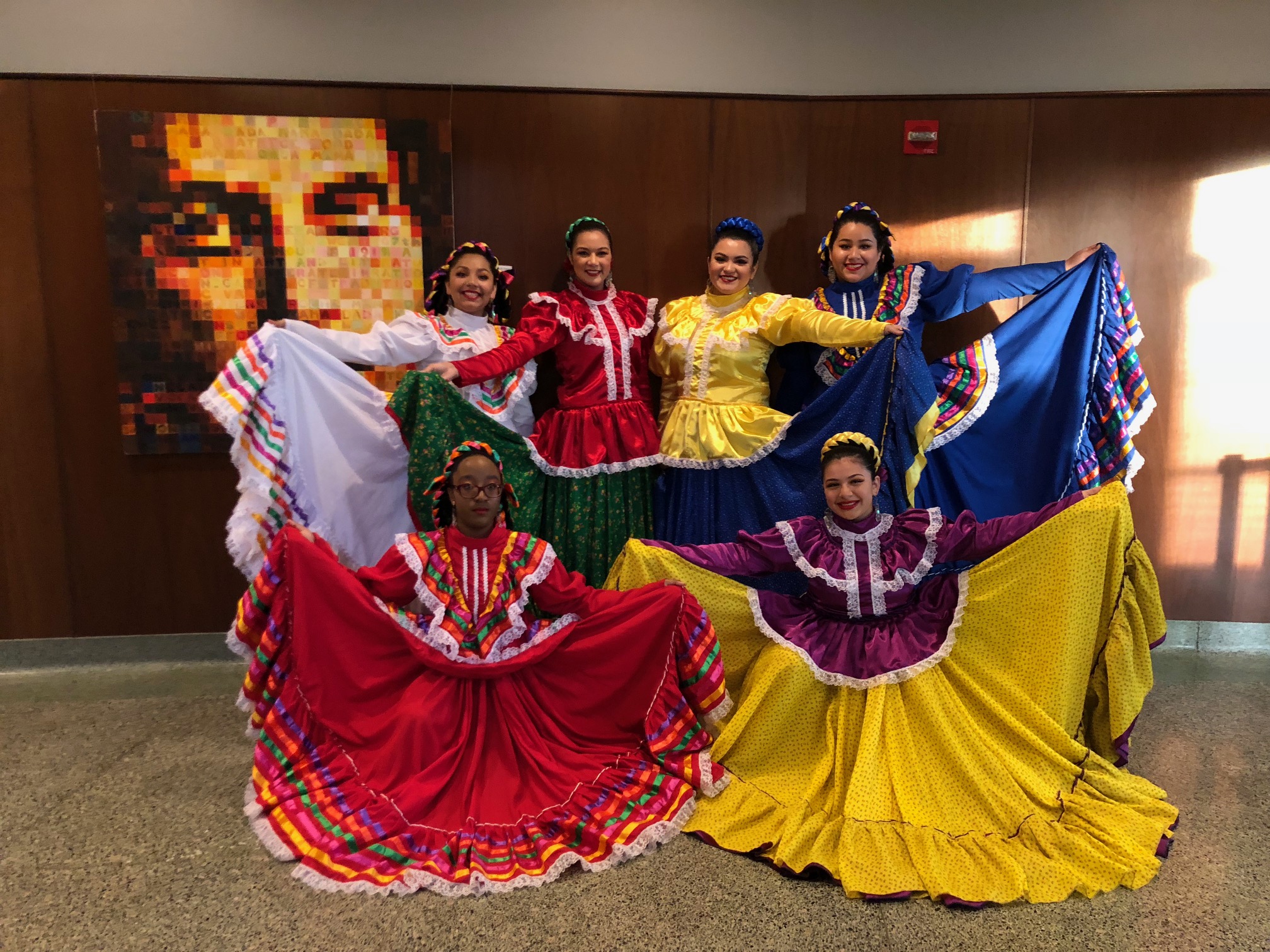 6 women wearing traditional dresses.