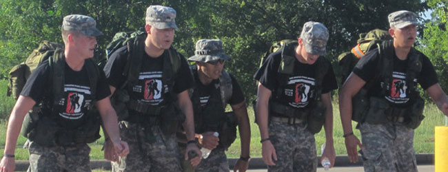 five men walking next to each other in gear