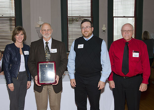 Melinda Holt, Bobby Lane, John Pascarella, and David Burns posing with their award plaque