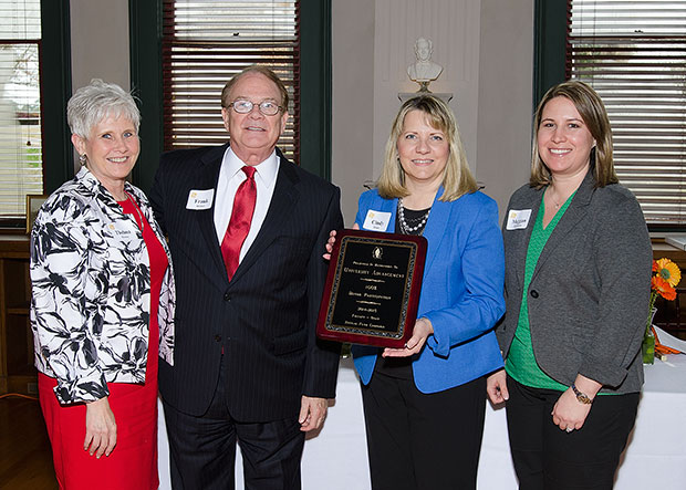 Thelma Mooney, Frank Holmes, Cindy Truax, and Meggan Thompson posing with their award plaque