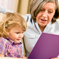 Older woman reading a book with a toddler as part of the Full Circle Literacy project at SHSU