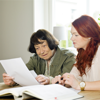 Older adult writing with a younger adult 