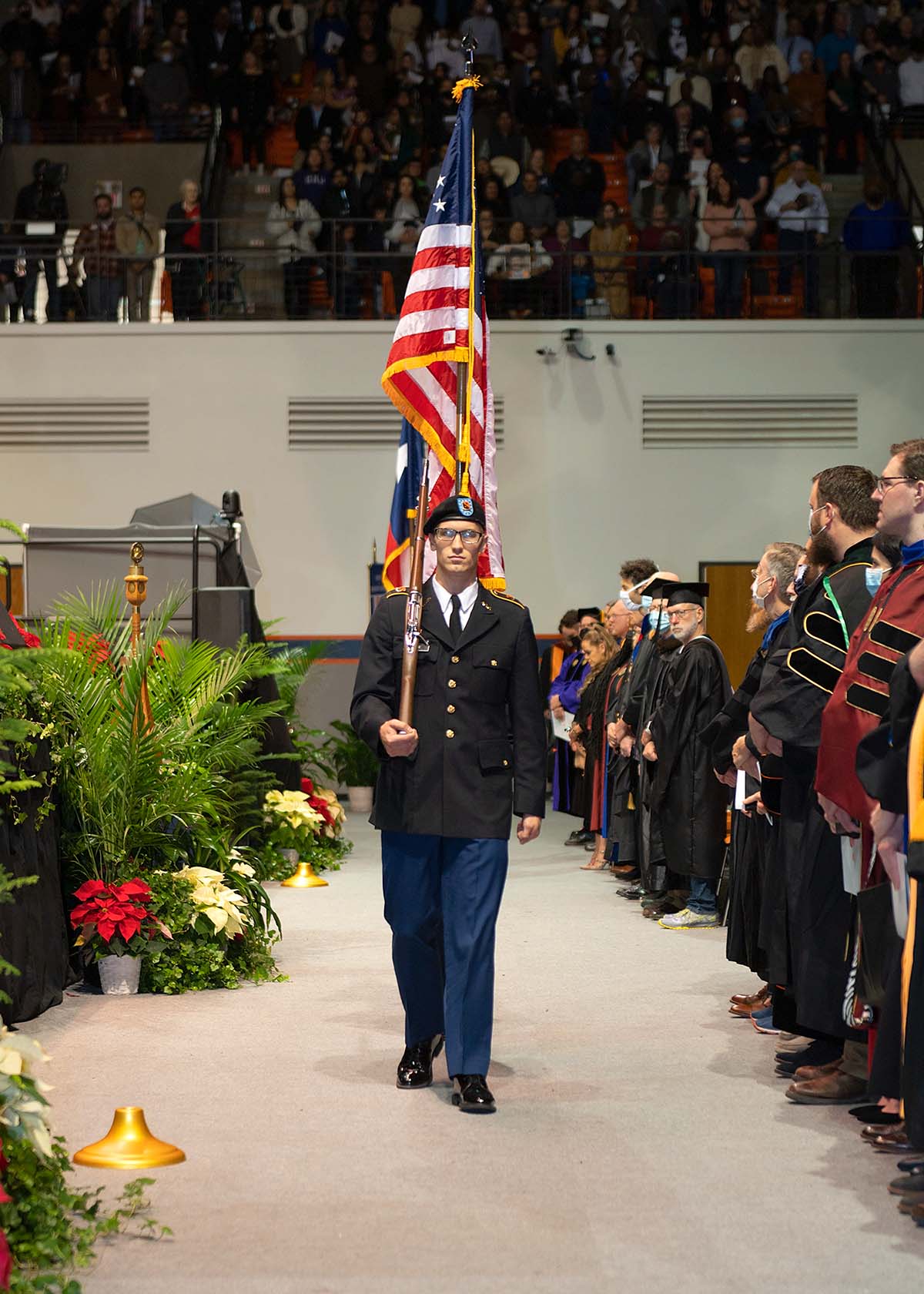 SHSU ROTC Color Guard carrying the United States flag on the floor of the coliseum.