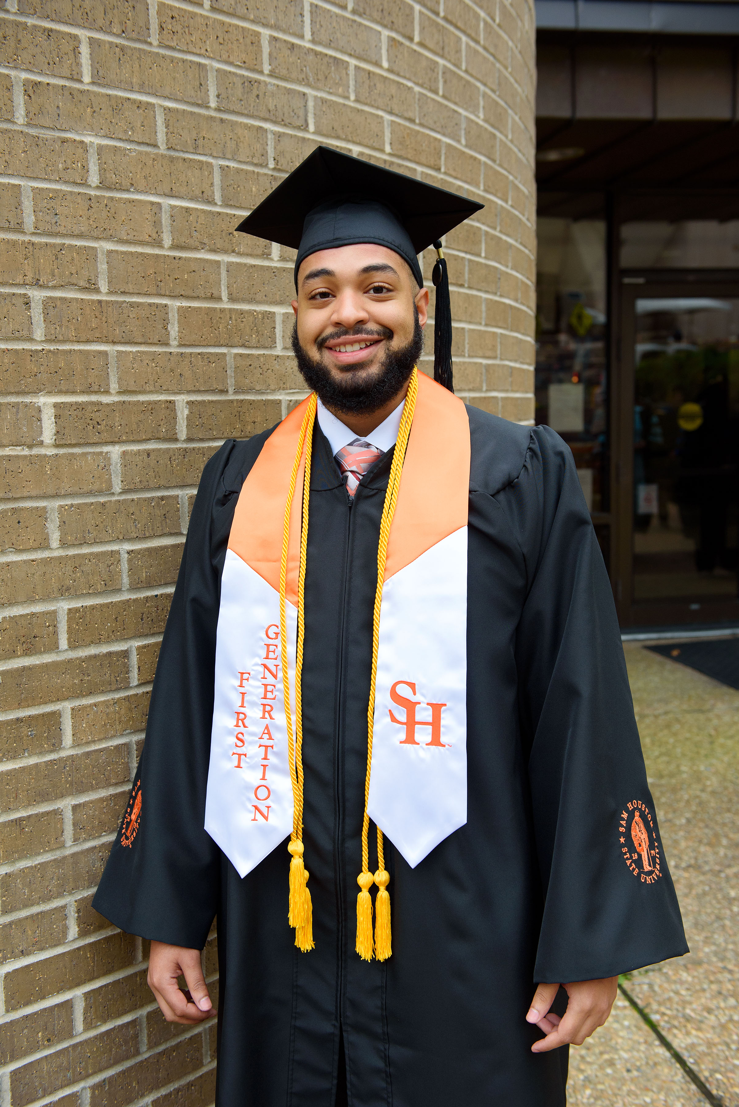 A first-generation graduate poses before his ceremony.