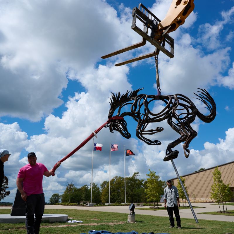 Workers install sculpture 