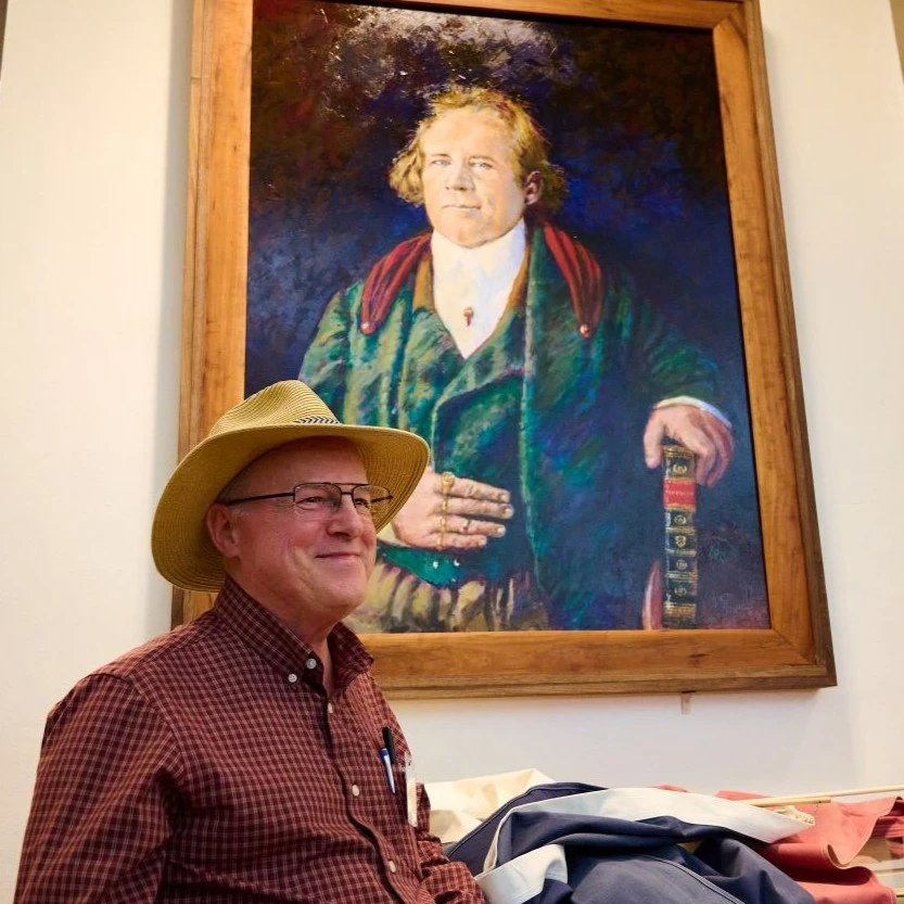 artist Lee Jamison in front of painting of Sam Houston.