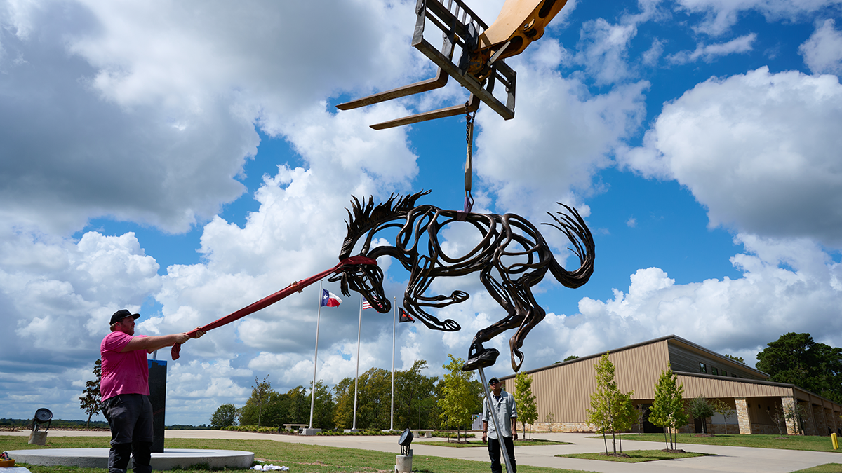 Workers install sculpture 