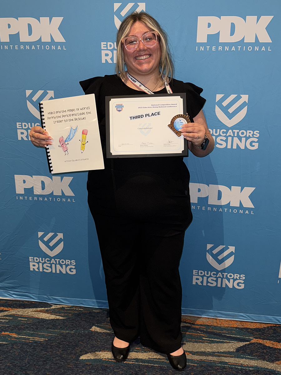 Alexis Argueta holds her third place award and a copy of her award-winning submission, "Miles and the Magic of Words: Penny Pencil and Eddie the Eraser to the Rescue!"