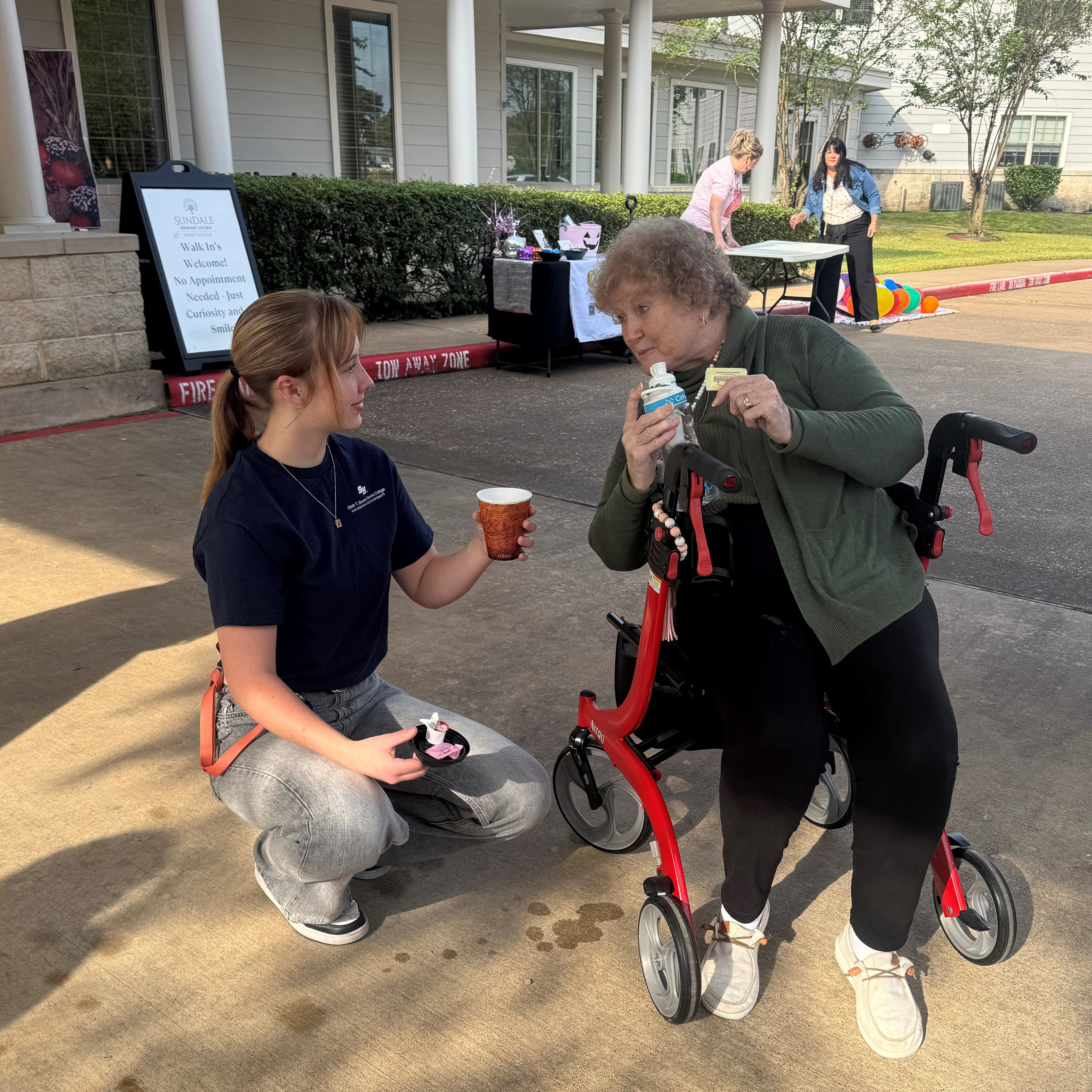 An SHSU Honors student interacts with a resident of the Sundale Senior Living Facility during their fall festival.