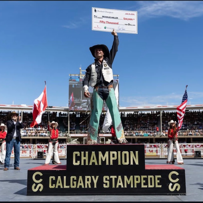 Bradlee Miller holds a check aloft at the Calgary Stampede Championship.