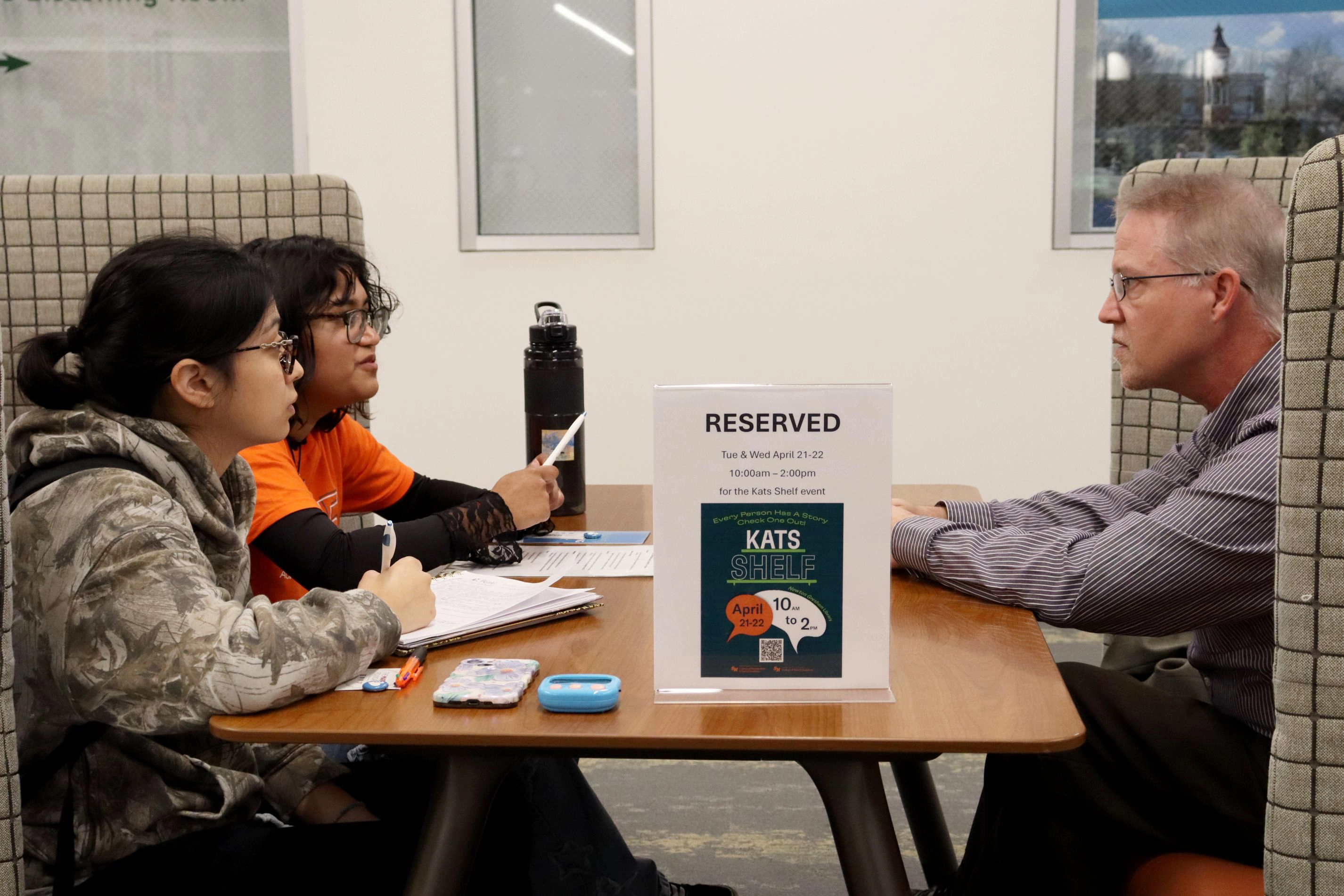students talking with professor in library at SHSU