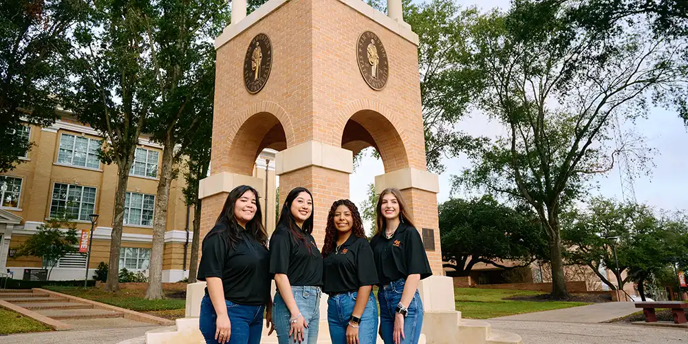 Four members of ASPIRE standing in front of the clock tower.