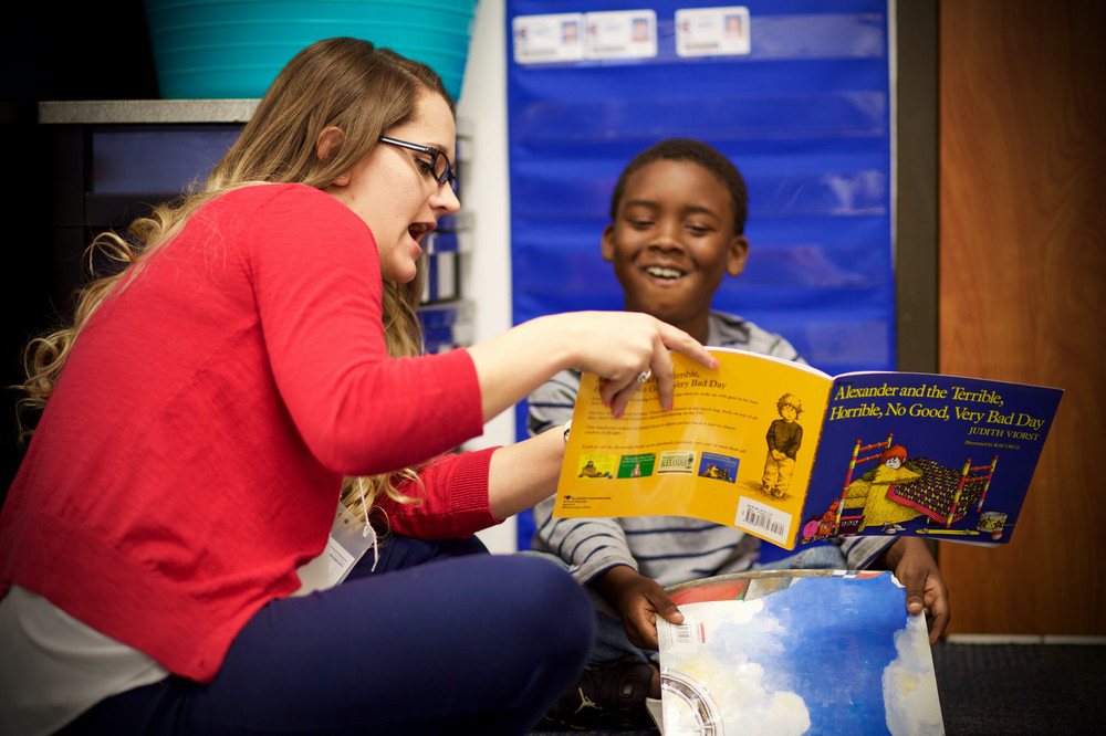Student reading to child