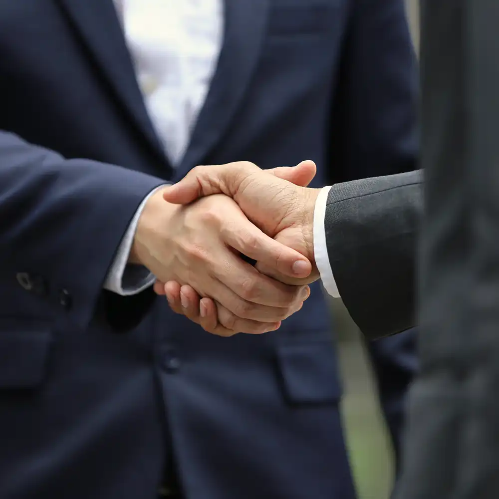 A handshake between two people in an office